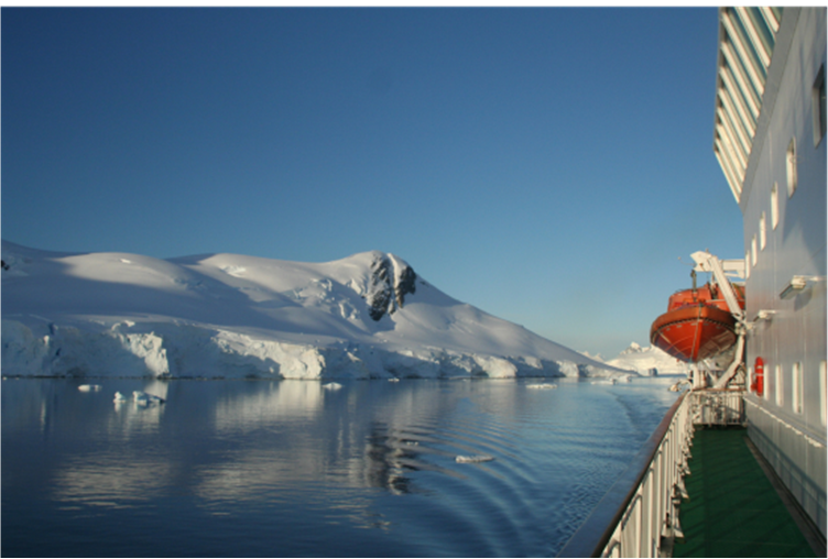 Expedition ship with zodiac near icebergs